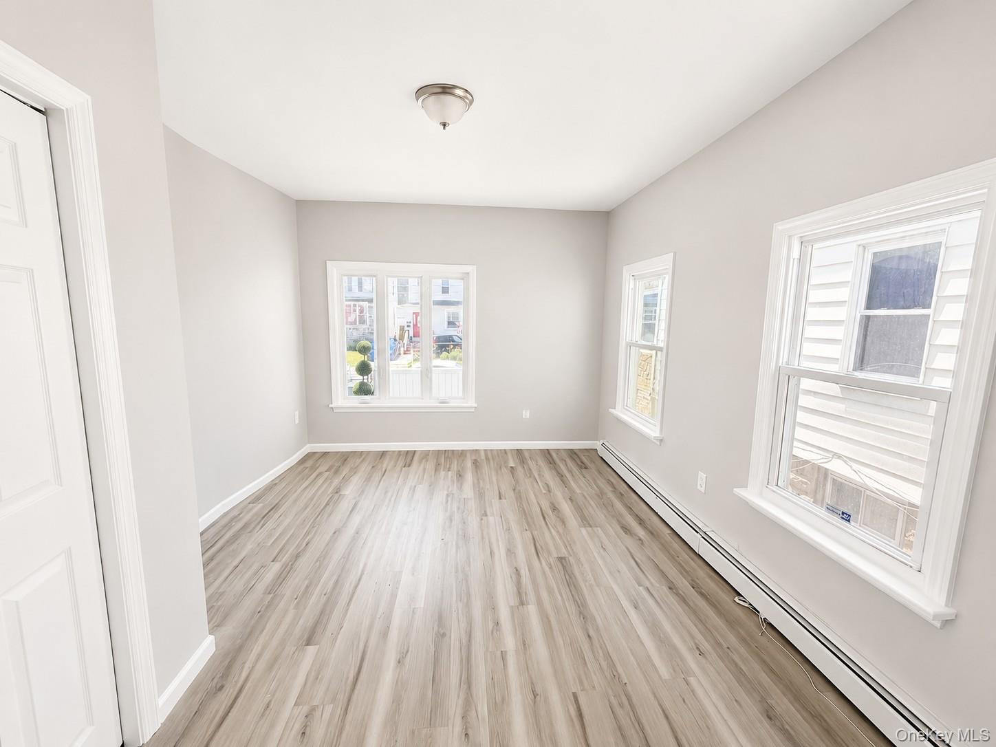 25 Monroe Street, Unit 1 Mount Vernon, NY 10550 - Photo 6 of 11 Bedroom featuring wood-finish flooring, light gray wall tones, and white baseboards