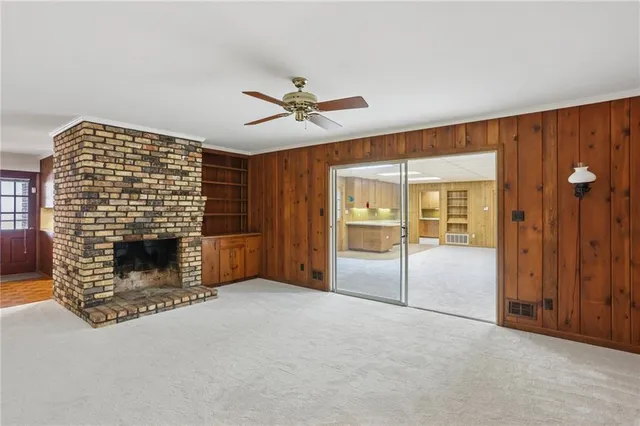 a view of an empty room with a fireplace and a window