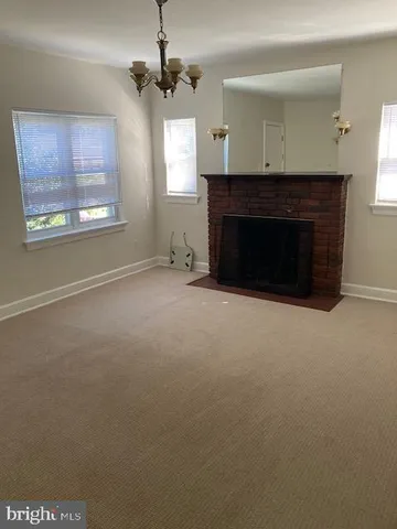 a view of an empty room with a fireplace and a window