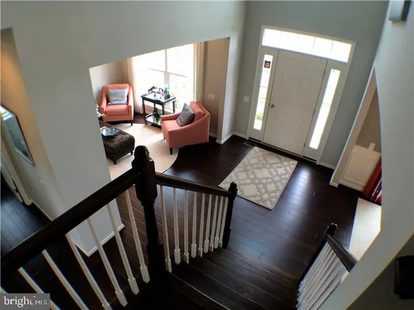 a view of a hallway with couches and a dining table chairs