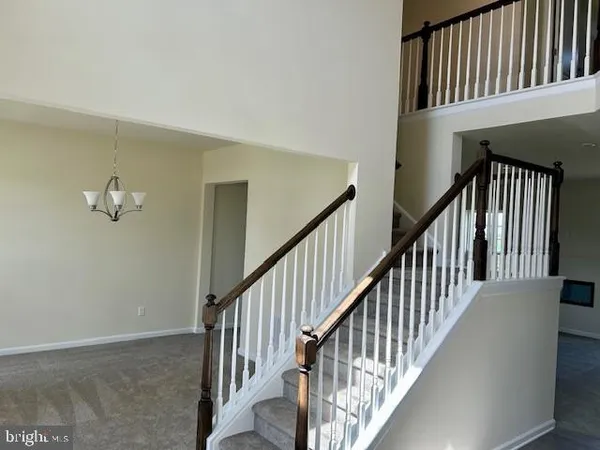 a view of staircase with wooden floor and fan