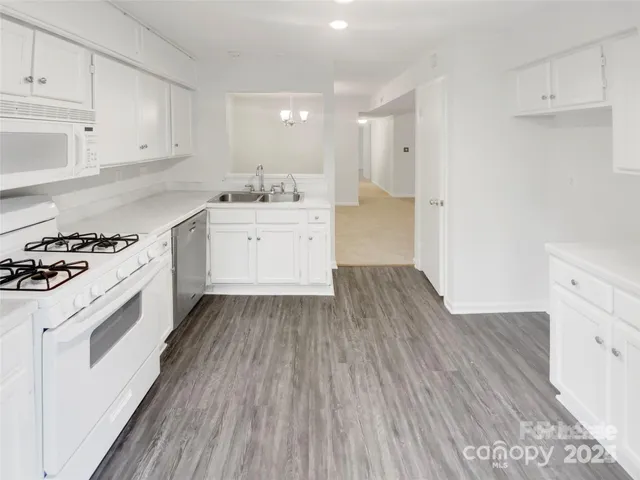 a kitchen with wooden floors and white appliances