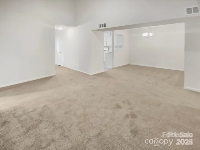 an empty room with windows and fireplace