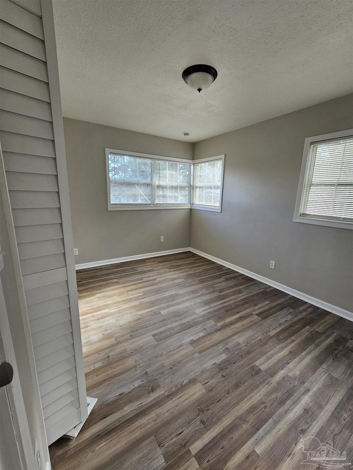5357 Locklin Avenue Milton, FL 32570 - Photo 8 of 9 wooden floor in an empty room with a window