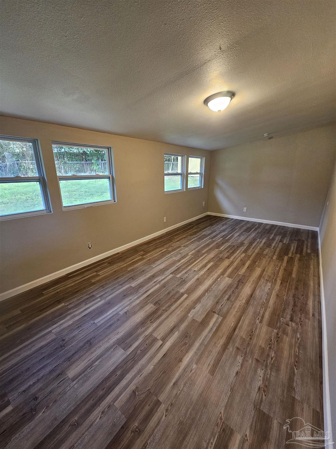 5357 Locklin Avenue Milton, FL 32570 - Photo 9 of 9 wooden floor in an empty room with a window
