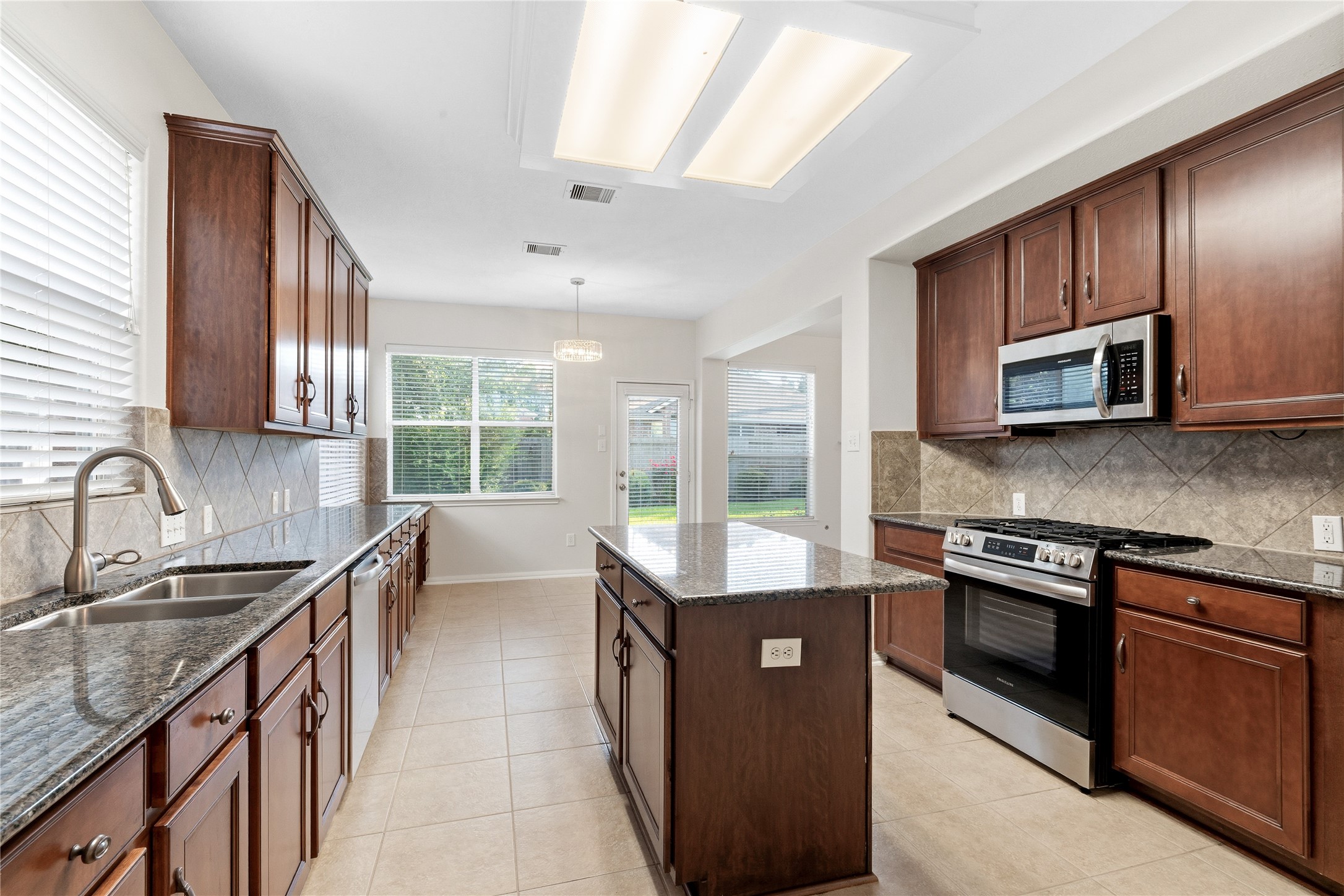 6211 Stone Hill Road Spring, TX 77389 - Photo 14 of 43 a kitchen with stainless steel appliances granite countertop a sink stove and microwave