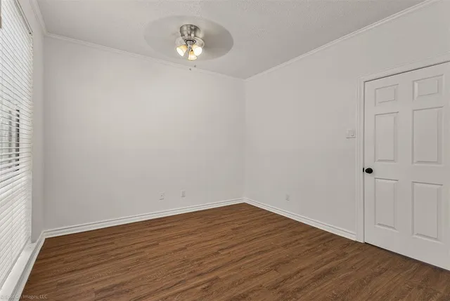 a view of empty room with wooden floor and window