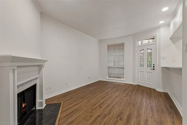 an empty room with wooden floor and fireplace