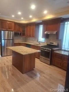 a kitchen with stainless steel appliances granite countertop a stove a sink and a microwave