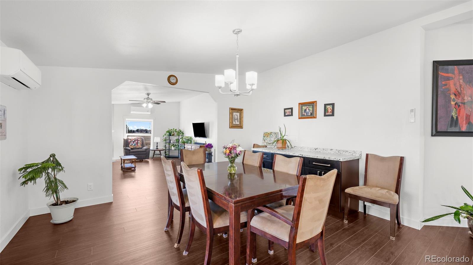 12340 Smith Road Peyton, CO 80831 - Photo 15 of 49 a view of a dining room with furniture wooden floor and chandelier