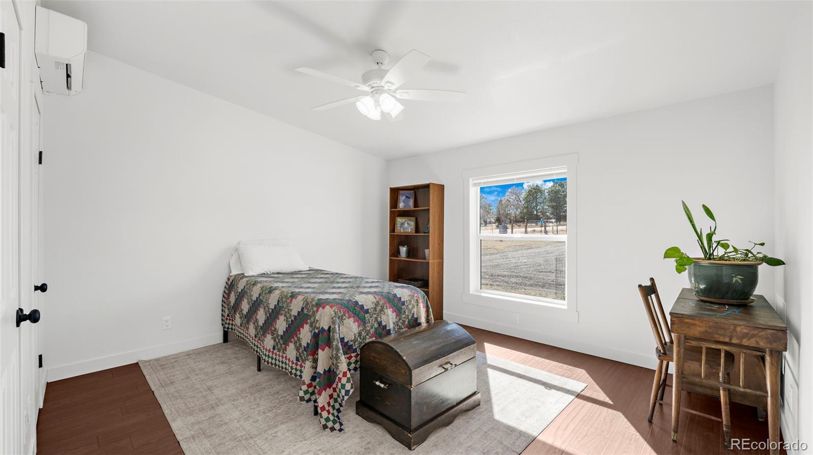 12340 Smith Road Peyton, CO 80831 - Photo 20 of 49 a bedroom with a bed and wooden floor