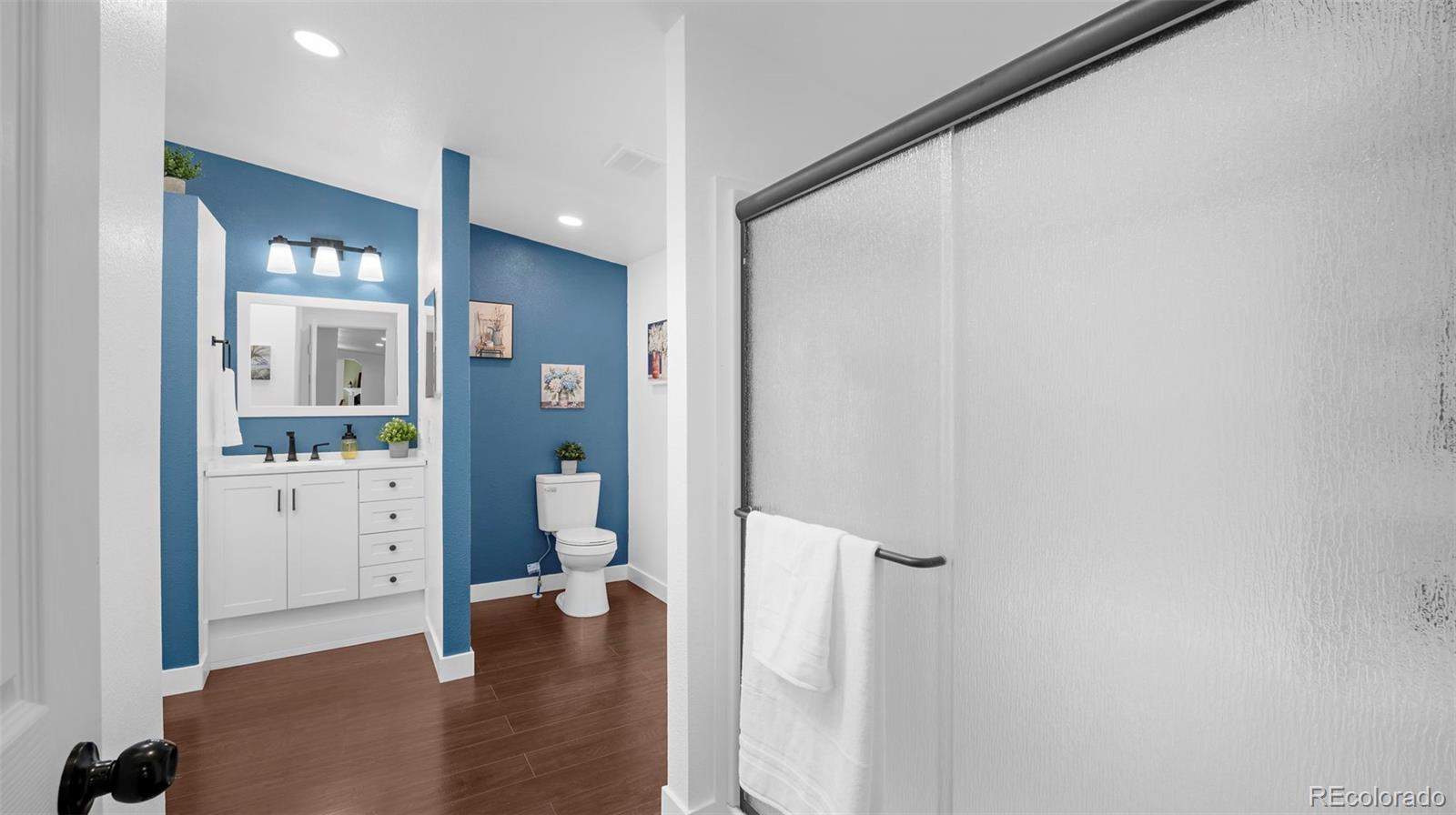 12340 Smith Road Peyton, CO 80831 - Photo 26 of 49 a view of a hallway with wooden floor and a bathroom