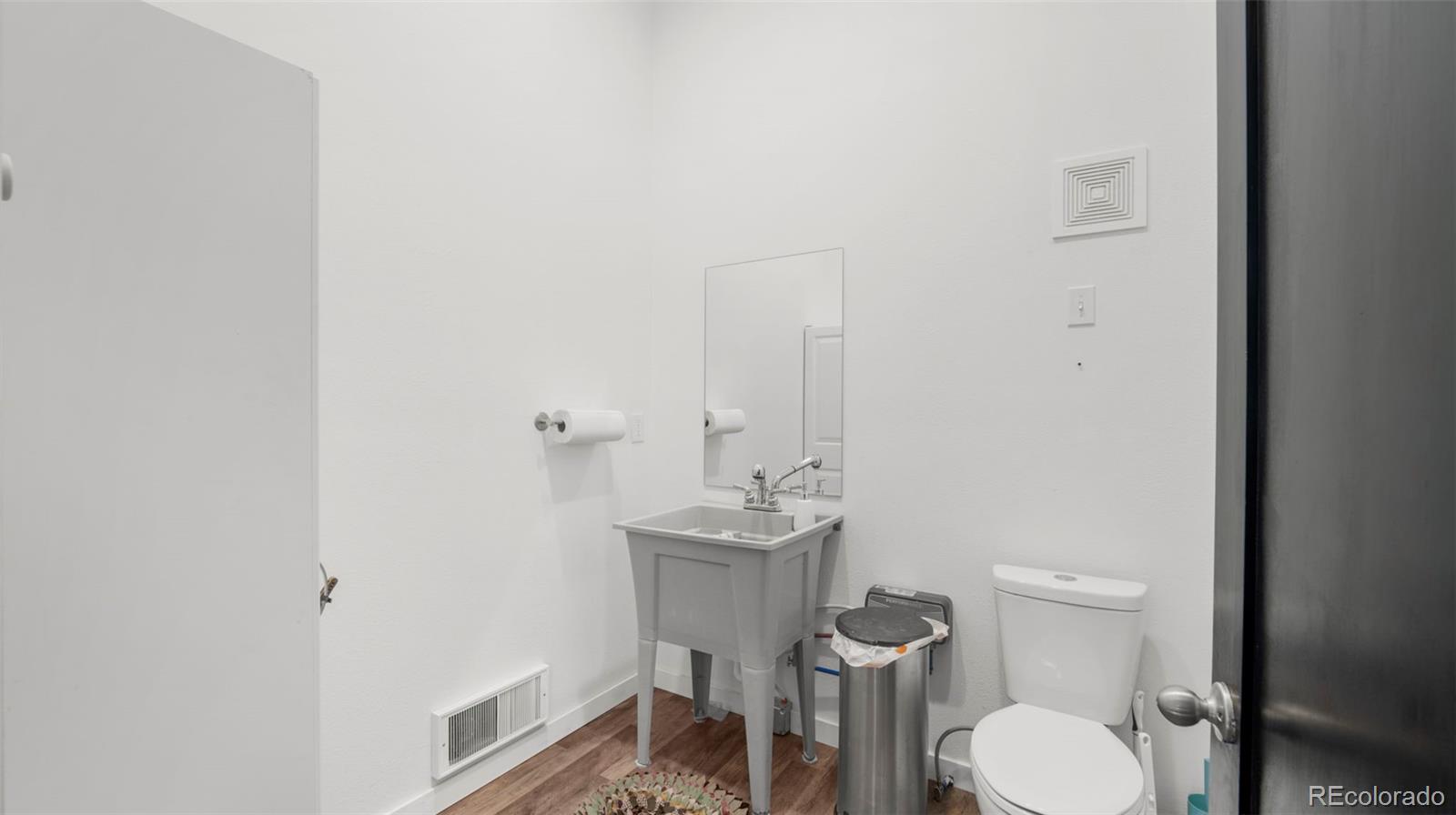 12340 Smith Road Peyton, CO 80831 - Photo 33 of 49 a bathroom with a toilet a sink and mirror