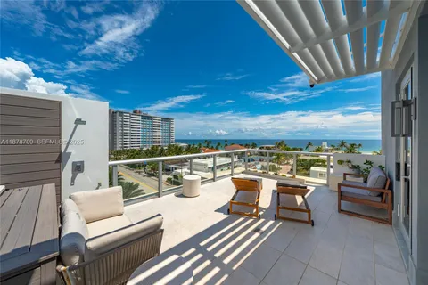 a view of a roof deck with couches and potted plants