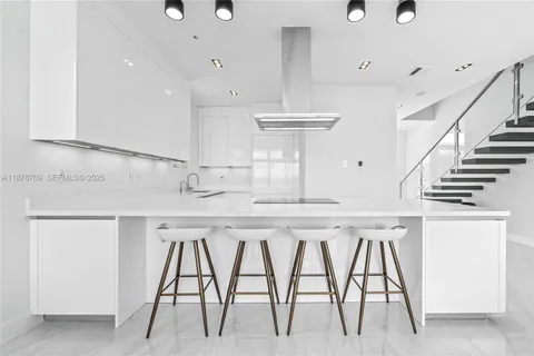 a kitchen with a table chairs sink and cabinets
