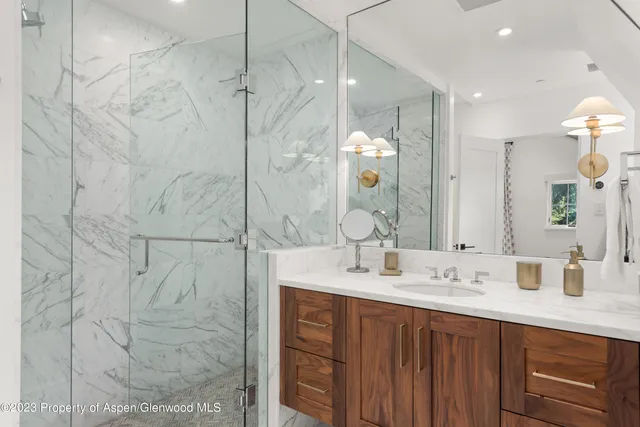 a bathroom with a double vanity sink mirror and shower