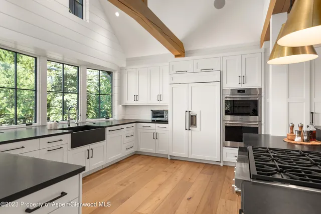 a kitchen with stainless steel appliances granite countertop a stove a sink and a refrigerator
