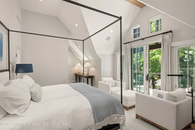 a living room with furniture a rug and wall paintings