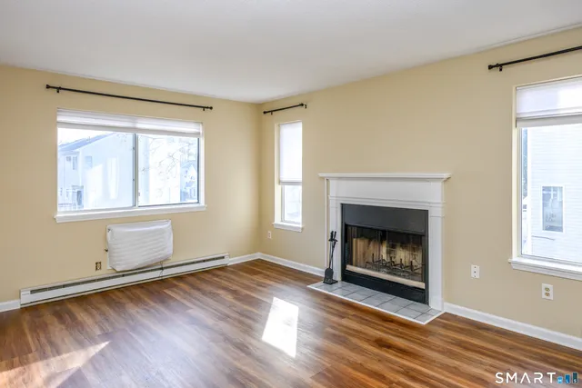 a living room with wooden floor and a fireplace