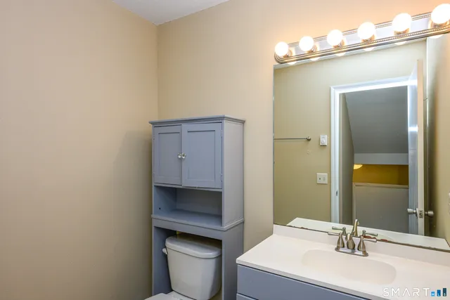 a bathroom with a toilet sink and mirror