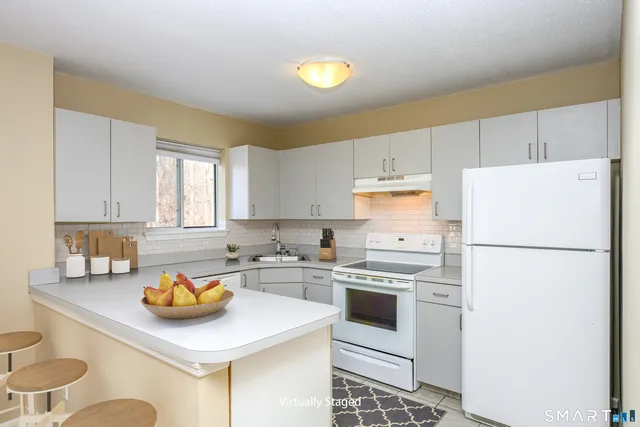 a kitchen with a white cabinets stove and refrigerator