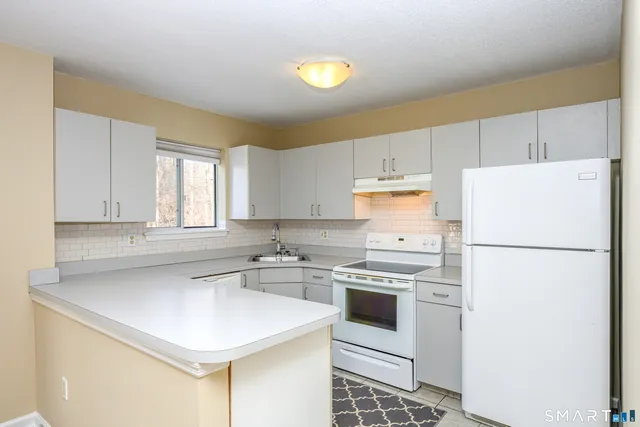 a kitchen with a white cabinets stove and refrigerator