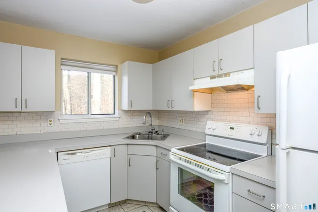 a kitchen with white cabinets appliances and sink