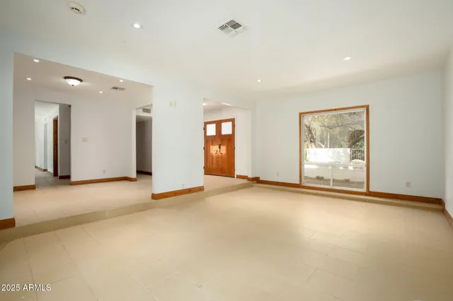 an empty room with closet and a chandelier fan
