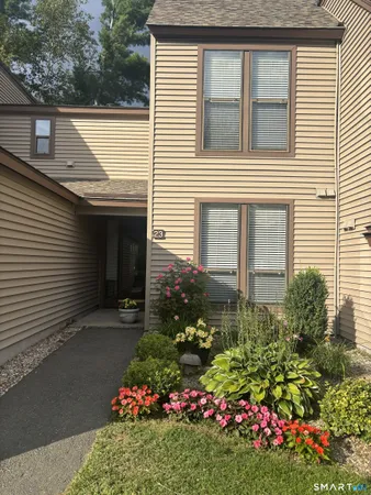 a view of a house that has a flower garden