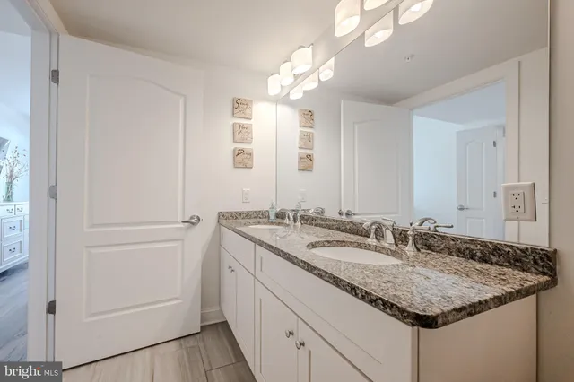 a bathroom with a granite countertop sink and a mirror