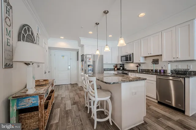 a kitchen with stainless steel appliances granite countertop a sink a stove and refrigerator