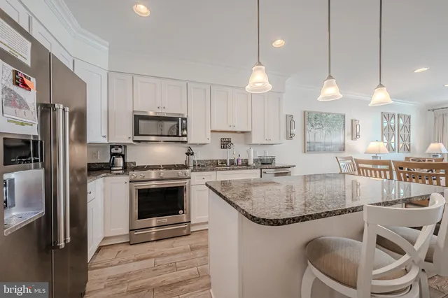 a kitchen with granite countertop a stove a sink and a refrigerator