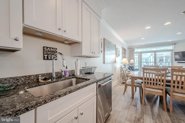a kitchen with granite countertop a sink a stove and cabinets