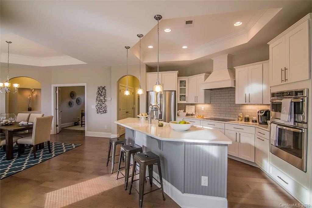 3002 Portico Place, Unit 38 Tega Cay, SC 29708 - Photo 17 of 38 a large kitchen with cabinets chairs and wooden floor