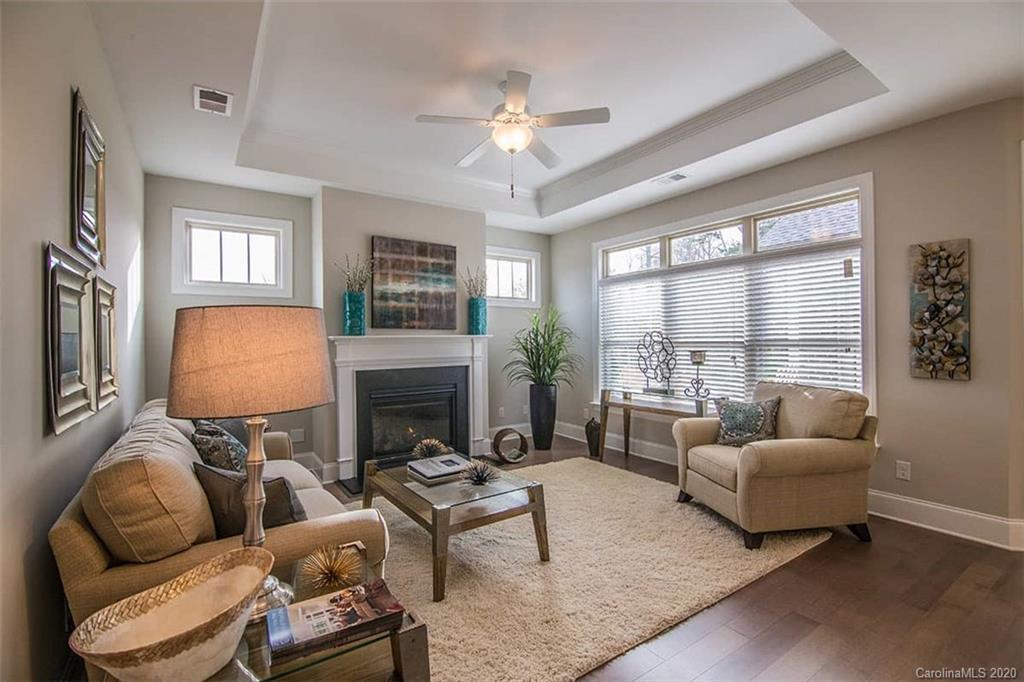 3002 Portico Place, Unit 38 Tega Cay, SC 29708 - Photo 20 of 38 a living room with furniture a large window and a fireplace