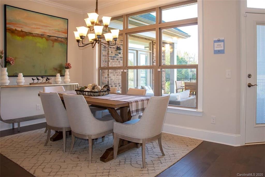 3002 Portico Place, Unit 38 Tega Cay, SC 29708 - Photo 22 of 38 a dining room with furniture a chandelier and wooden floor