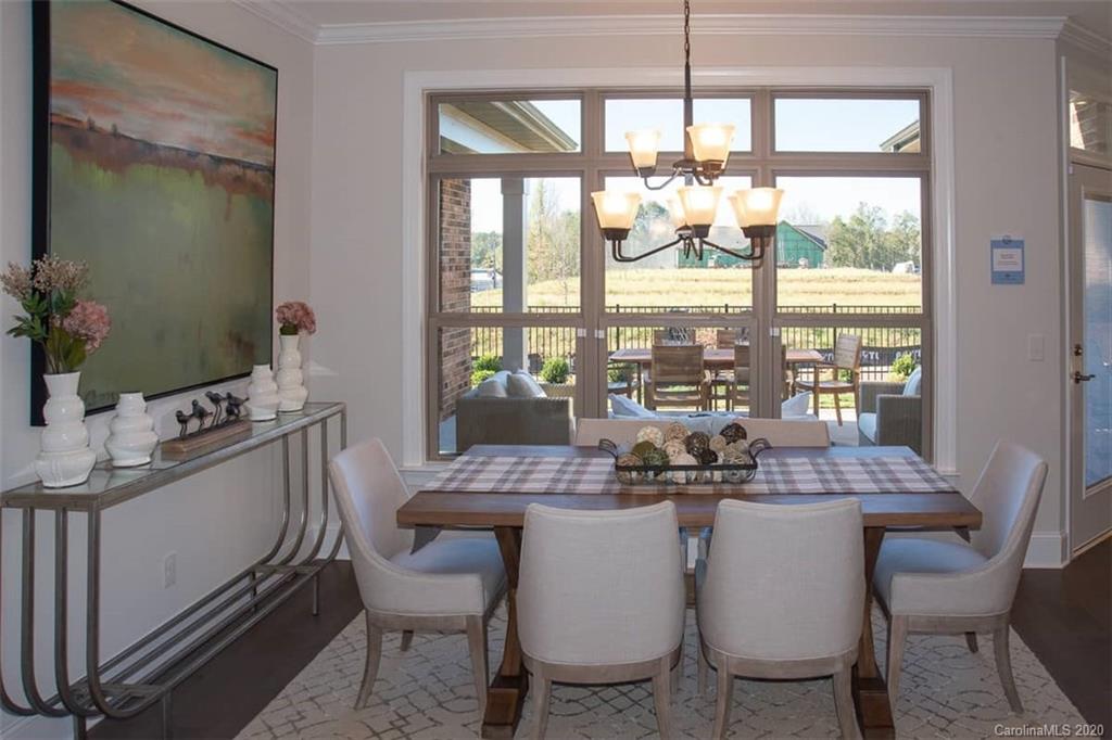 3002 Portico Place, Unit 38 Tega Cay, SC 29708 - Photo 23 of 38 a dining room with furniture a chandelier and wooden floor