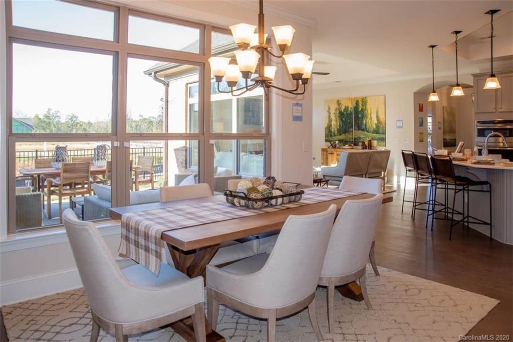 3002 Portico Place, Unit 38 Tega Cay, SC 29708 - Photo 24 of 38 a view of a dining room with furniture a chandelier and wooden floor