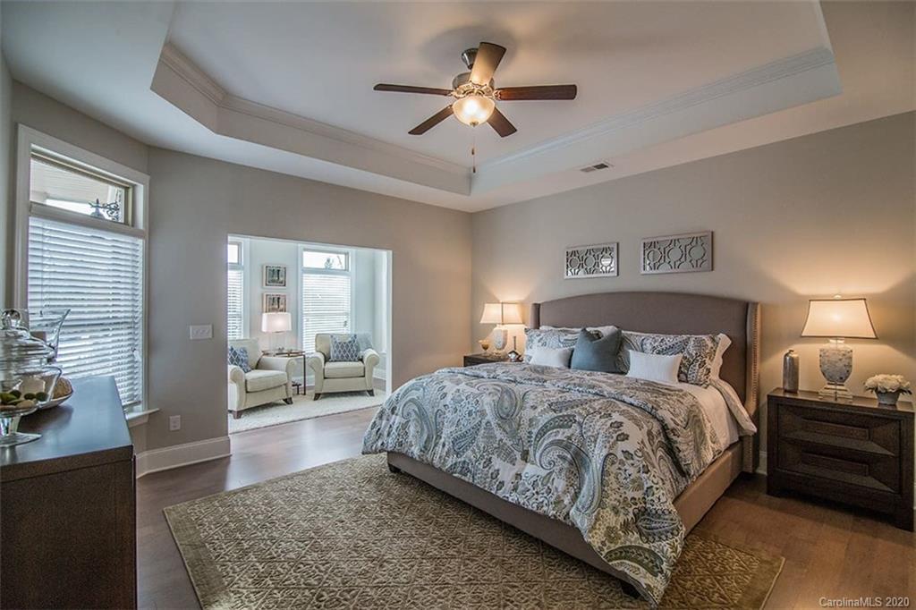 3002 Portico Place, Unit 38 Tega Cay, SC 29708 - Photo 30 of 38 a bedroom with a large bed a chandelier and windows