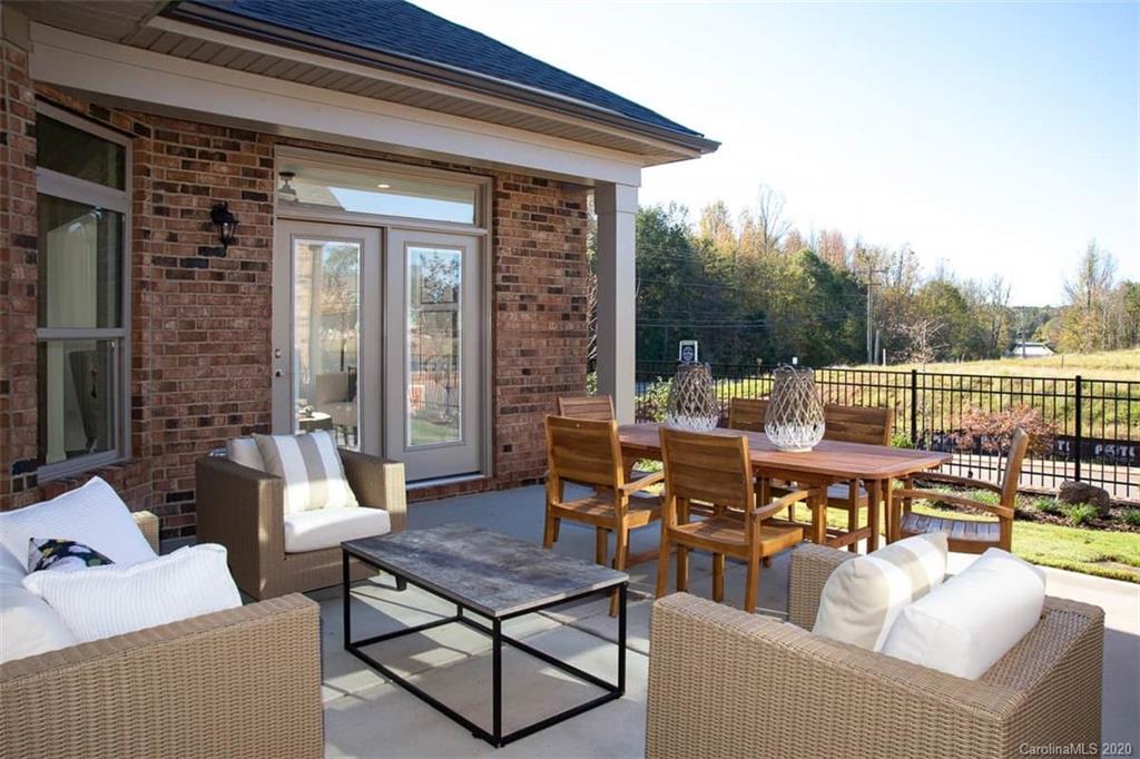 3002 Portico Place, Unit 38 Tega Cay, SC 29708 - Photo 6 of 38 a view of a patio with couches table and chairs and potted plants