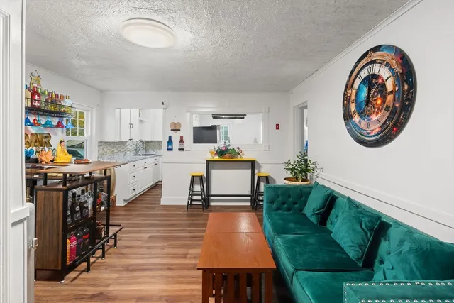 a kitchen with stainless steel appliances a stove a refrigerator and a view of living room