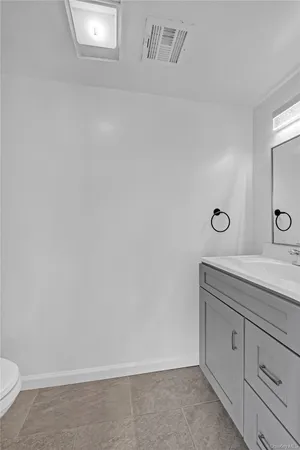 a bathroom with a granite countertop sink and toilet