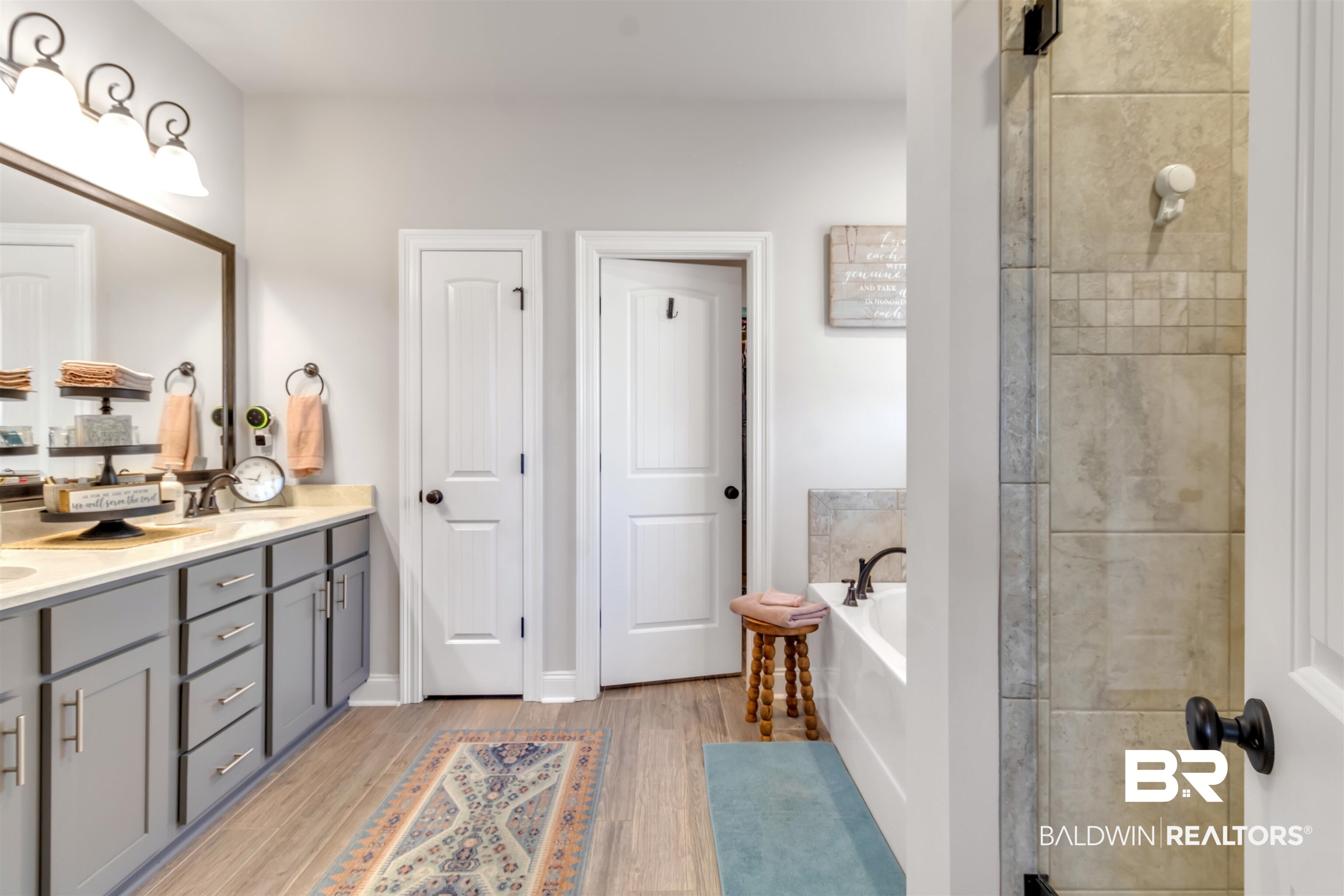 22531 Putter Lane Foley, AL 36535 - Photo 25 of 43 Bathroom featuring double vanity, a garden tub, a stall shower, and light wood-type flooring