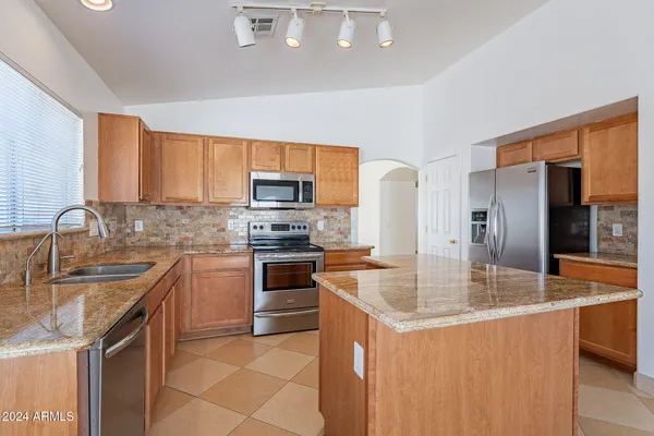 a kitchen with stainless steel appliances granite countertop a sink stove and refrigerator