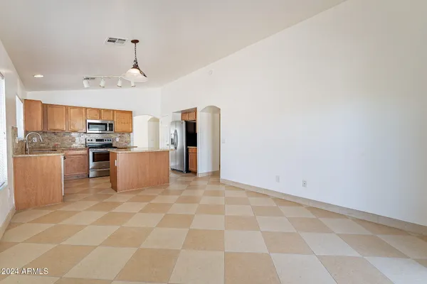 a kitchen with stainless steel appliances granite countertop a refrigerator a stove top oven and white cabinets