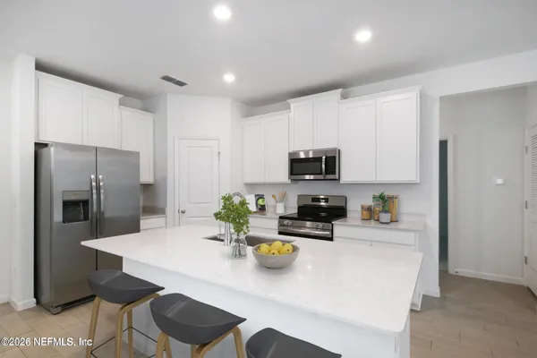 a kitchen with stainless steel appliances a refrigerator sink and cabinets