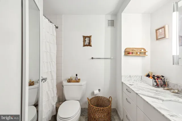 a bathroom with a granite countertop toilet sink and a shower
