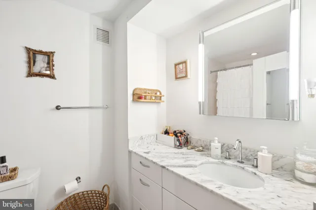 a bathroom with a granite countertop sink and a mirror