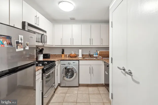 a utility room with cabinets washer and dryer