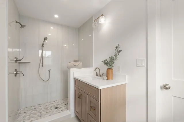 a bathroom with a shower sink and mirror